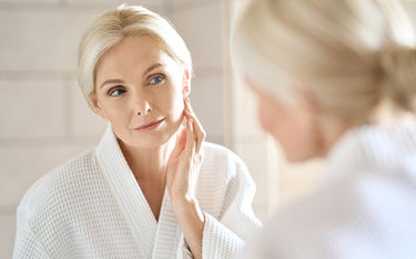 Kobieta w średnim wieku przegląda się w lustrze